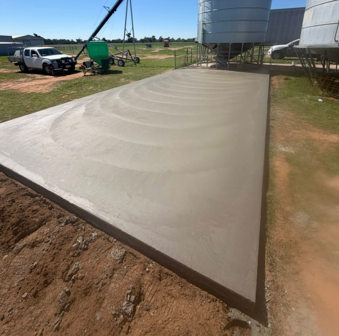 Finished concrete slab beside grain silo